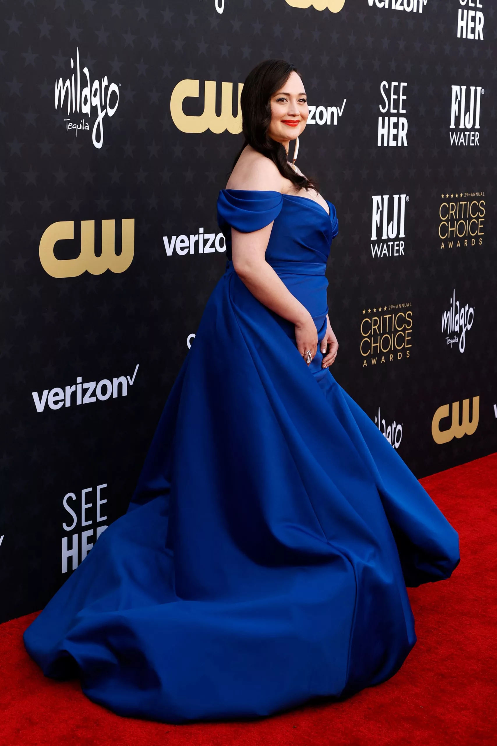 Lily Gladstone wore a deep blue satin dress by Christian Siriano, with her lipstick adding an extra pop of color.
