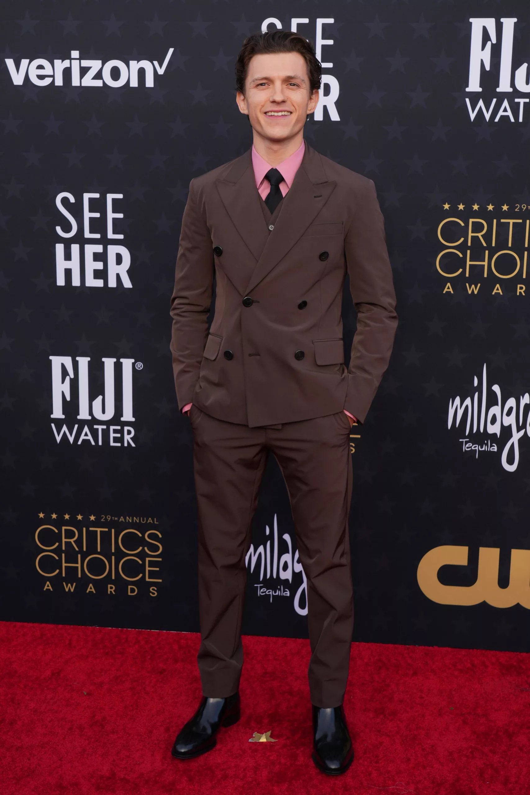 Tom Holland looked dapper in head-to-toe Prada, with a pink poplin shirt adding a pop of color to his all-brown suit.